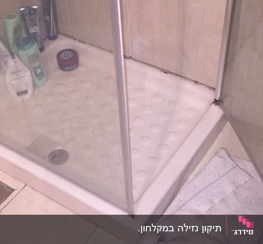 מקלחון עם מגבת על הרצפה ליד הניקוז